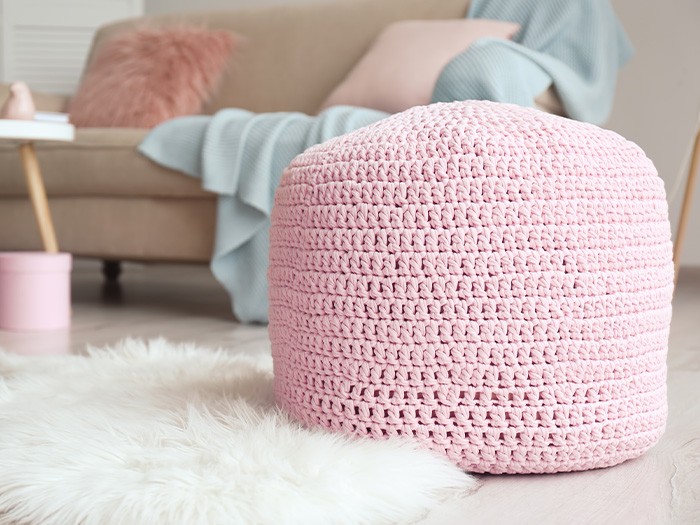 Salon avec un pouf rose.