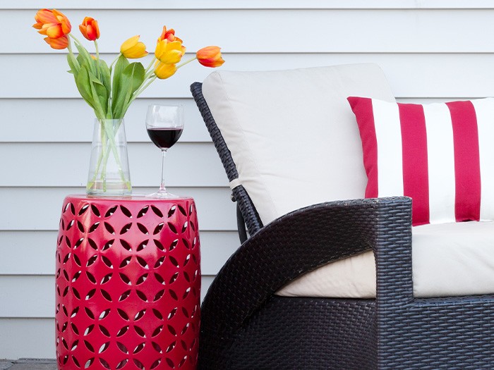 Petite table d’appoint avec des fleurs à côté d’une chaise de patio.