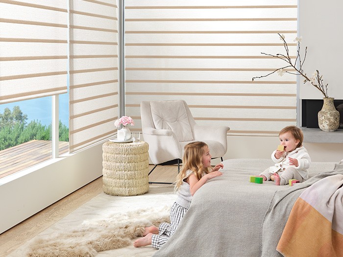 Chambre d’enfant dont les fenêtres sont équipées de stores romains modernes Vignette avec automatisation PowerViewMD.